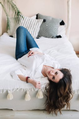 Sabahları yatakta yatan genç ve güzel bir kadının portresi. Yatak odasında güzel bir esmer. İyi sabahlar. Yaşam biçimi.