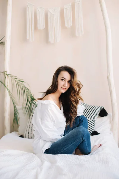 Portrait of a young beautiful woman in bed in the morning at home. Beautiful brunette in the bedroom. Good morning. Lifestyle. — Stock Photo, Image