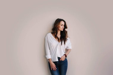 Koyu saçlı güzel bir kadının portresi. Stüdyoda poz veren güzel bir esmer. Romantik çekim.