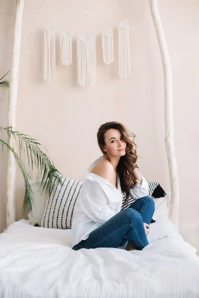 Portrait of a young beautiful woman in bed in the morning at home. Beautiful brunette in the bedroom. Good morning. Lifestyle. — Stock Photo, Image