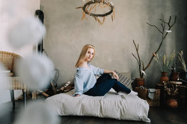 Retrato de uma jovem mulher bonita na cama pela manhã em casa. Menina loira no interior escandinavo. Bom dia. Estilo de vida . — Fotografia de Stock