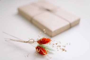 Kahverengi el işi kağıdıyla sarılmış ve jütüyle süslenmiş güzel bir hediye kutusu. Doğum günü, düğün ve kız işi konsept.  