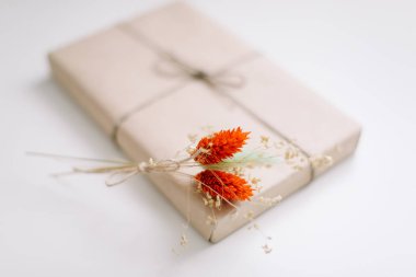 Kahverengi el işi kağıdıyla sarılmış ve jütüyle süslenmiş güzel bir hediye kutusu. Doğum günü, düğün ve kız işi konsept.  