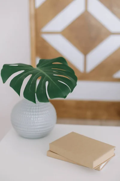 Huisdecoratie. Een boek en een palmblad in vaas op tafel. Vlakke wip. gezellig huis — Stockfoto