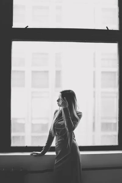 Young woman portait indoors. Silhouette of a girl in front of a window. black and white photography, monochrome, photo noir — Stock Photo, Image