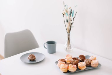 Masada şekerleme ve çiçek olan bir fincan kahve. Romantik bir sabah. Lezzetli bir kahvaltı. Düz konum, üst görünüm, kopyalama alanı.