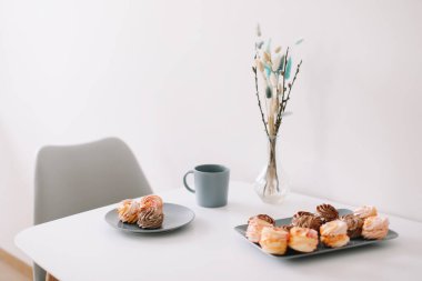 Masada şekerleme ve çiçek olan bir fincan kahve. Romantik bir sabah. Lezzetli bir kahvaltı. Düz konum, üst görünüm, kopyalama alanı.