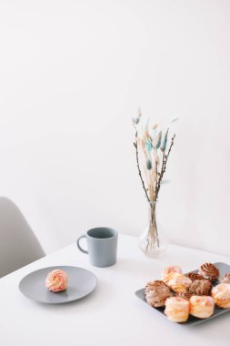 Masada şekerleme ve çiçek olan bir fincan kahve. Romantik bir sabah. Lezzetli bir kahvaltı. Düz konum, üst görünüm, kopyalama alanı.