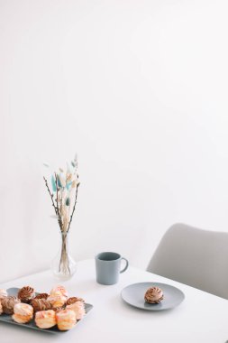 Masada şekerleme ve çiçek olan bir fincan kahve. Romantik bir sabah. Lezzetli bir kahvaltı. Düz konum, üst görünüm, kopyalama alanı.