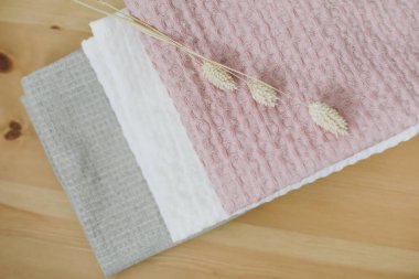 Mutfak masasında bir yığın temiz pamuk havlu. Pastel renkler. Yemek fotoğrafı. Doğal keten kumaş. Kırsal çiftlik tarzı