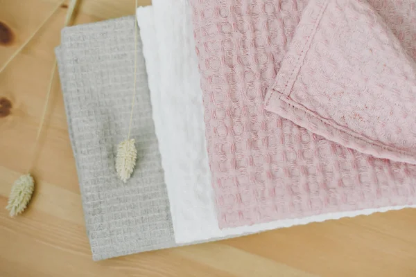 Montón de toallas de algodón de lino limpio en la mesa de la cocina. Colores pastel. Foto de comida. Tejido de algodón de lino natural. Estilo de granja rústico — Foto de Stock