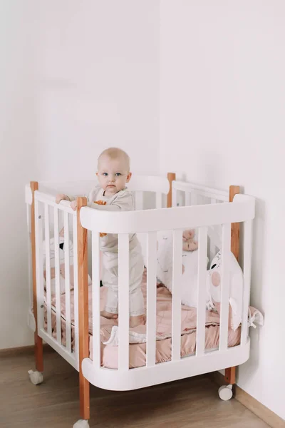 Schattige kleine baby staan in wieg thuis. — Stockfoto