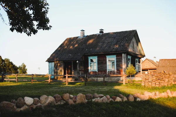 Oud houten huis in het dorp. Nationale houten boerderij in Wit-Rusland. Uitzicht op rustiek etnisch huis bij zonsondergang. Landelijk landschap — Stockfoto