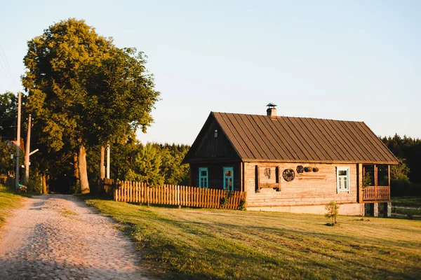 Vieille maison en bois dans village. Ferme nationale en bois au Bélarus. Vue de la maison ethnique rustique sur le coucher du soleil. Paysage rural — Photo