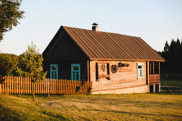 Oud houten huis in het dorp. Nationale houten boerderij in Wit-Rusland. Uitzicht op rustiek etnisch huis bij zonsondergang. Landelijk landschap — Stockfoto