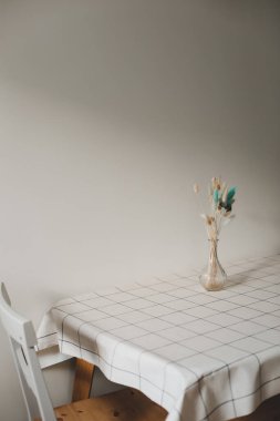 Modern yemek odası. Bir buket çiçek ve sandalyeli bir masa. Modern mutfak iç mimarisi. Güneşli bir sabah. Rahat bir ev. iç tasarım