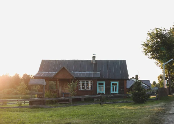 Köydeki eski ahşap ev. Beyaz Rusya 'da bir çiftlik evi. Gün batımında kırsal etnik ev manzarası. Kırsal alan — Stok fotoğraf