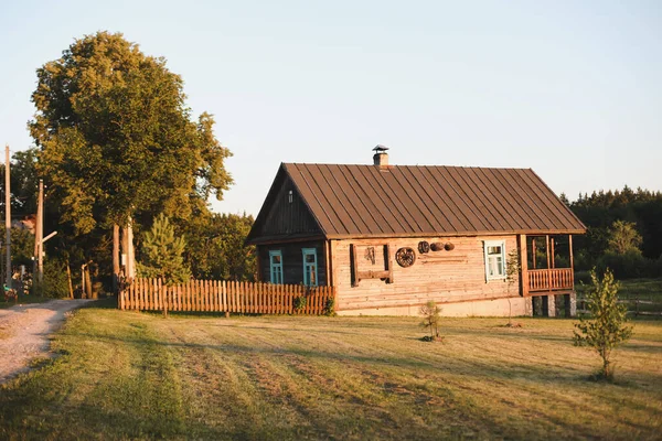 Altes Holzhaus im Dorf. Bauernhaus in Weißrussland. Blick auf rustikales ethnisches Haus bei Sonnenuntergang. Ländliche Landschaft — Stockfoto