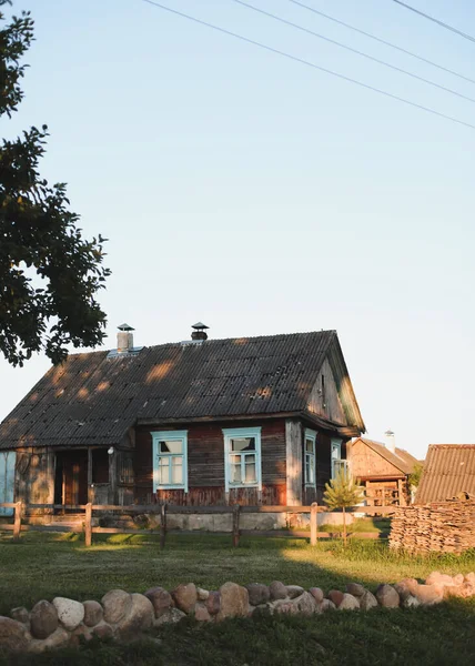 Starý dřevěný dům ve vesnici. Farmu v Bělorusku. Pohled na venkovský etnický dům při západu slunce. venkovská krajina — Stock fotografie