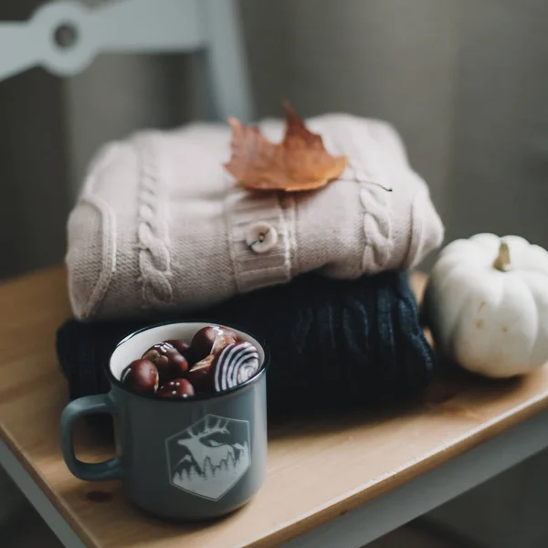 Pilha de roupas de malha em fundo de madeira, suéteres, malhas, folhas. Outono acolhedor, conceito de inverno. Camisolas de lã de malha — Fotografia de Stock