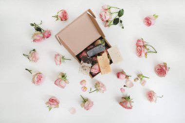 Beyaz arka planda pembe güller ve taç yaprakları olan doğal ev yapımı organik sabun. Spa konsepti, üst görünüm, düz çizgi 