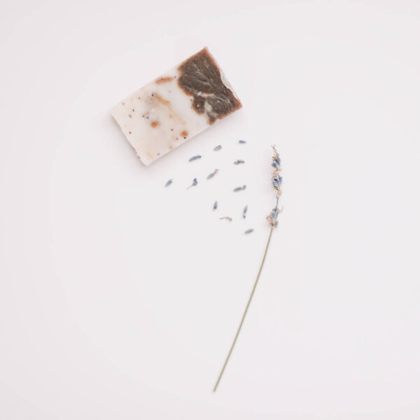 Мыло ручной работы и лаванда на белом фоне, вид сверху. Лавандовые цветы натуральное мыло для ухода за телом 