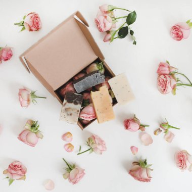 El işi hediye kutusu ve çiçekler. Kutudaki güller, çiçek arkaplanlı beyaz masa. çevrimiçi alışveriş ve moda kavramı