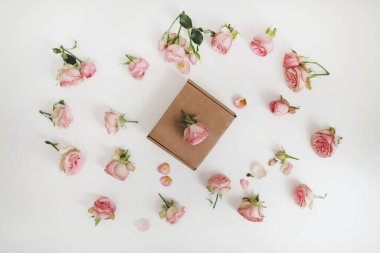 Beyaz arka planda pembe gül çiçekleri olan hediye kutusu. Tebrik kartı. Üst Manzara Düzlüğü. Tatil, düğün, doğum günü konsepti