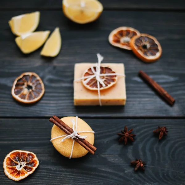 Naturalne ręcznie robione mydło z suszonymi plastrami pomarańczy i cynamonu na ciemnym tle. Pojęcie Spa, pielęgnacji ciała i skóry. — Zdjęcie stockowe