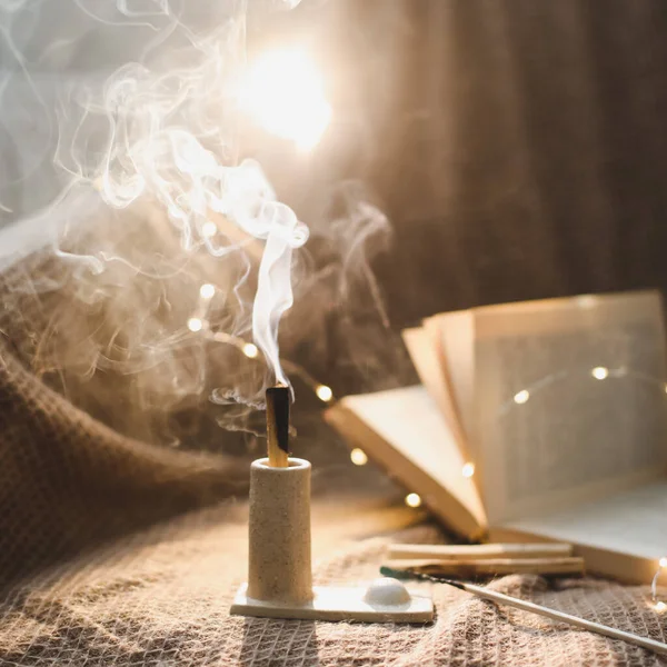 Palo Santo träpinne brinner med rök i en vacker ljusstake. Meditation, avslappningskoncept. Mysig kväll hemma — Stockfoto