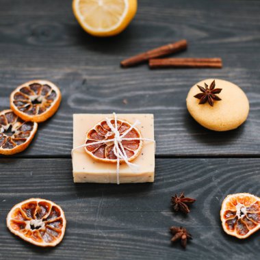 Koyu arkaplanda kurumuş portakal dilimleri olan doğal el yapımı sabun. Vücut ve cilt bakımı. Düz yatıyordu. Metin için boşluk, üst görünüm