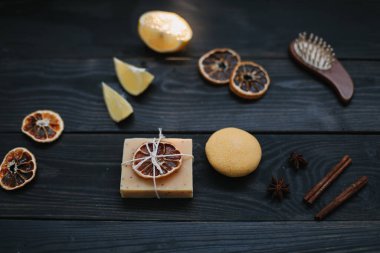 Koyu arkaplanda kurumuş portakal dilimleri olan doğal el yapımı sabun. Vücut ve cilt bakımı. Düz yatıyordu. Metin için boşluk, üst görünüm