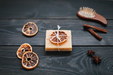 Koyu arkaplanda kurumuş portakal dilimleri olan doğal el yapımı sabun. Vücut ve cilt bakımı. Düz yatıyordu. Metin için boşluk, üst görünüm