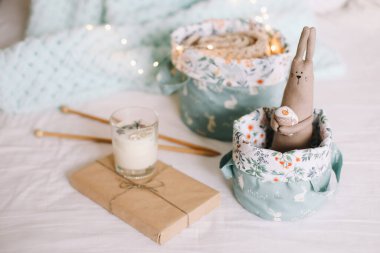 Oyuncak sepetleri, iplikler, iğneler, örülmüş giysiler, arka planda Bokeh lambaları. İçerisi çocuk odası gibi. Kış ya da Noel havası