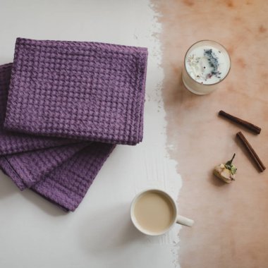 Kahve fincanı, tarçın ve beyaz ahşap arka planda peçeteler. Kahvaltı konsepti. Üst görünüm, düz görünüm