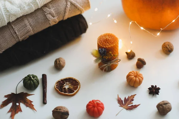 Cozy autumn composition. Pumpkin, wax candles, leaves. Hygge lifestyle, cozy autumn mood. Halloween, Happy Thanksgiving concept