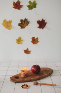 Ev dekorasyonu. Sonbahar kompozisyonu. Şamdandaki mumlar, beyaz arka plandaki kurumuş yapraklar. Sonbahar, Cadılar Bayramı konsepti. 