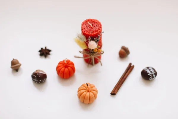 Herbst-Stillleben: Kerzen, Kürbis, Zimt, Kastanien, Eicheln auf weißem Hintergrund. Hygge-Lifestyle, gemütliche Wohnkultur. — Stockfoto