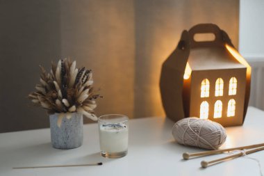 Mum, iplik ve örgü iğneleri. Eviniz güzelmiş. Hygge rahat bir hayat sürüyor. Noel, kış, yeni yıl geçmişi