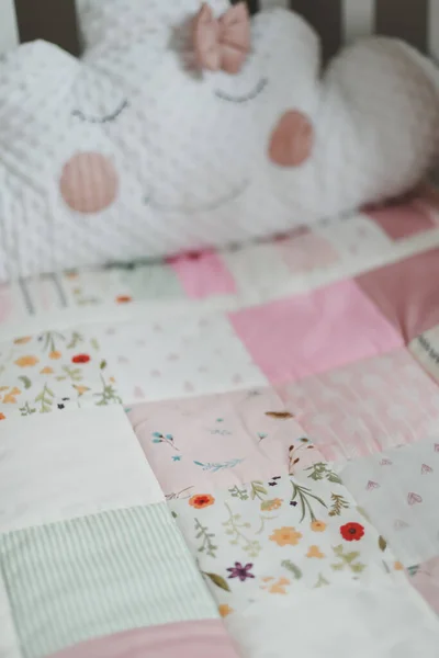 Acogedora cuna con manta patchwork rosa. Ropa de cama de bebé. Cuna, de cerca. Textil para guardería infantil. Siesta y tiempo de sueño —  Fotos de Stock