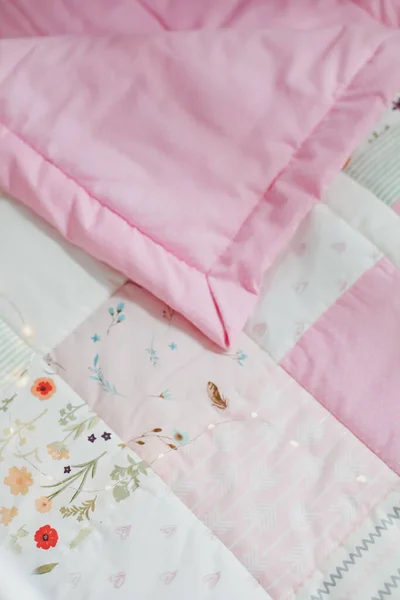 Acogedora cuna con manta patchwork rosa. Ropa de cama de bebé. Cuna, de cerca. Textil para guardería infantil. Siesta y tiempo de sueño —  Fotos de Stock