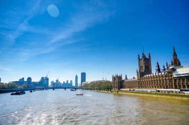 İngiltere 'nin başkenti Londra' da güneşli bir günde Thames nehri boyunca uzanan İngiliz Parlamentosu.