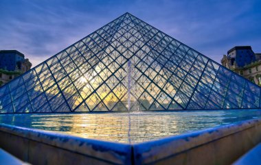 Paris, Fransa - 21 Nisan 2019 - Dünyanın en büyük sanat müzesi ve Paris, Fransa'da tarihi bir anıt olan Louvre Müzesi'nin güneşli bir günde manzarası.