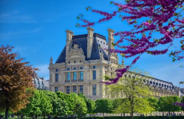 Paris, Fransa - 21 Nisan 2019 - Dünyanın en büyük sanat müzesi ve Paris, Fransa'da tarihi bir anıt olan Louvre Müzesi'nin güneşli bir günde manzarası.
