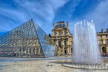 Paris, Fransa - 21 Nisan 2019 - Dünyanın en büyük sanat müzesi ve Paris, Fransa'da tarihi bir anıt olan Louvre Müzesi'nin güneşli bir günde manzarası.