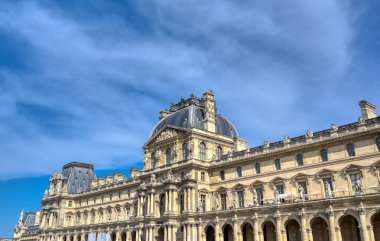 Paris, Fransa - 21 Nisan 2019 - Dünyanın en büyük sanat müzesi ve Paris, Fransa'da tarihi bir anıt olan Louvre Müzesi'nin güneşli bir günde manzarası.