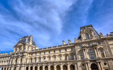 Paris, Fransa - 21 Nisan 2019 - Dünyanın en büyük sanat müzesi ve Paris, Fransa'da tarihi bir anıt olan Louvre Müzesi'nin güneşli bir günde manzarası.