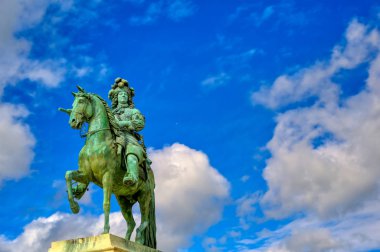 Versailles, Fransa - 24 Nisan 2019: Paris,Fransa'nın dışında güneşli bir günde Versailles Sarayı'nın kapılarının hemen dışında Louis Xiv heykeli.