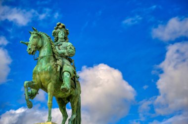 Versailles, Fransa - 24 Nisan 2019: Paris,Fransa'nın dışında güneşli bir günde Versailles Sarayı'nın kapılarının hemen dışında Louis Xiv heykeli.