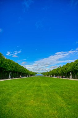 Versailles, Fransa - 24 Nisan 2019: Paris, Fransa dışında güneşli bir günde Versailles Sarayı'nın bahçesindeki heykeller ve çeşmeler.